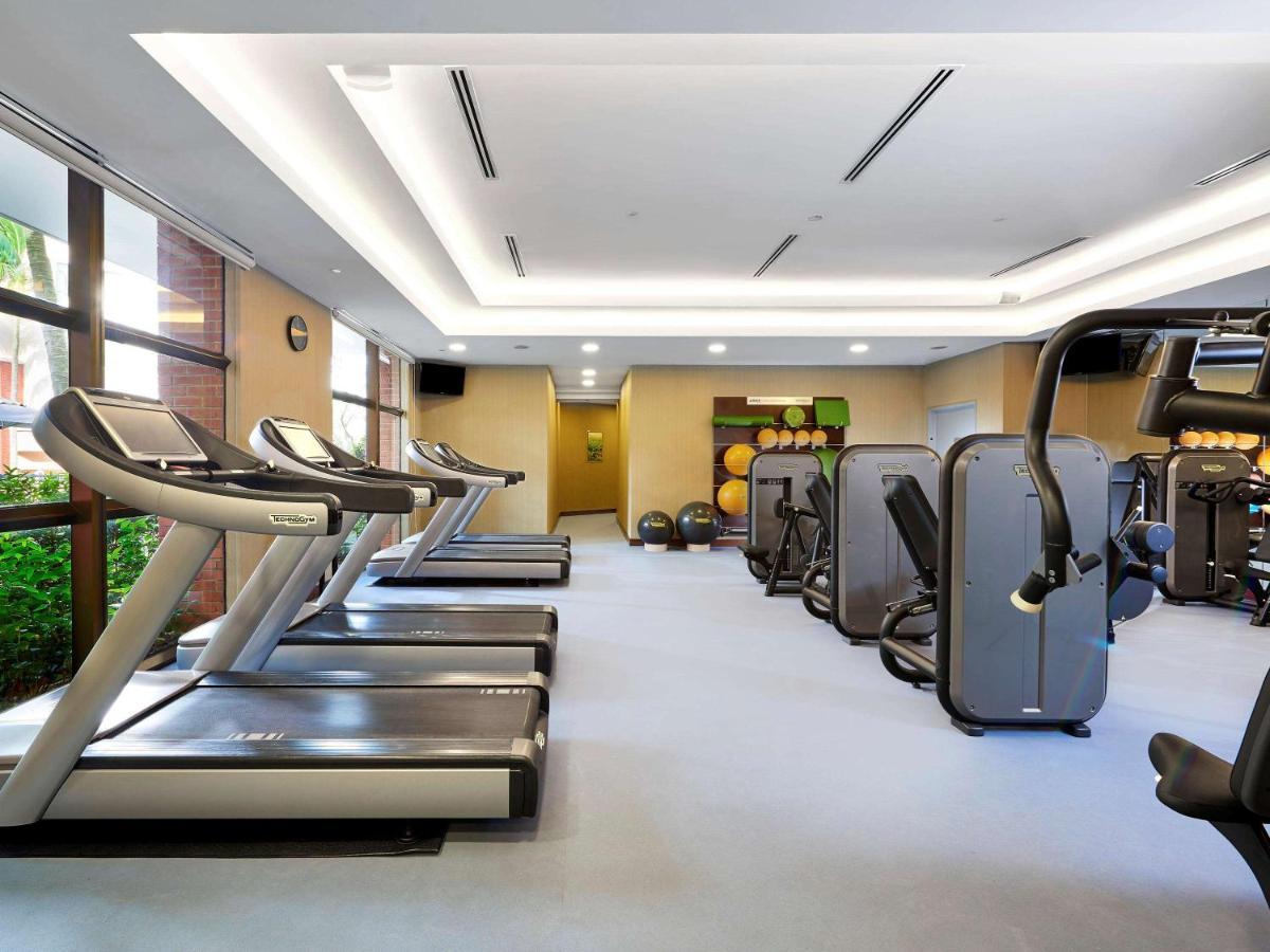 Paradox Singapore Merchant Court At Clarke Quay Екстериор снимка The photo shows a fitness gym interior that features several exercise machines and equipment. There are three treadmills positioned next to a large window, allowing natural light to enter the space. Alongside the treadmills, various types of strength