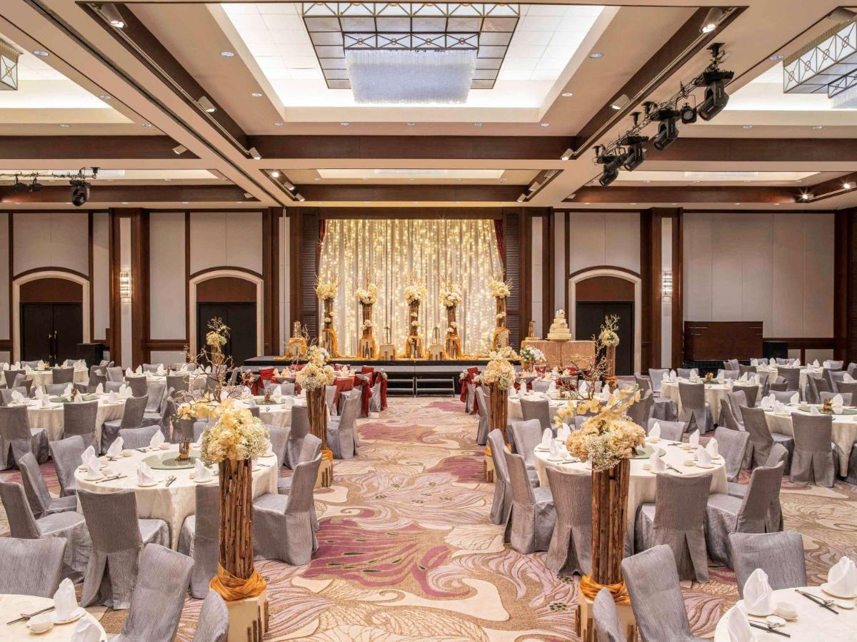 Paradox Singapore Merchant Court At Clarke Quay Екстериор снимка The photo depicts an elegant banquet hall set up for an event. The room features numerous round tables draped in white and gray tablecloths, each adorned with floral centerpieces. The chairs are covered in gray fabric with white accents. At the front