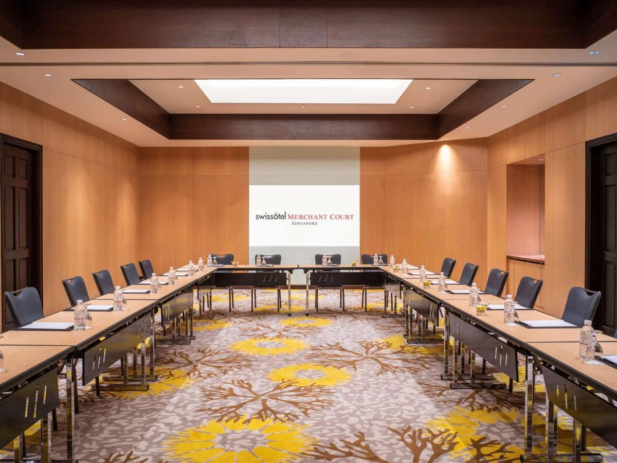 Paradox Singapore Merchant Court At Clarke Quay Екстериор снимка The image shows a professional conference room designed for meetings. It features a large rectangular arrangement of tables with black chairs surrounding them. The walls are made of light-colored wood, contributing to a modern and sophisticated atmos