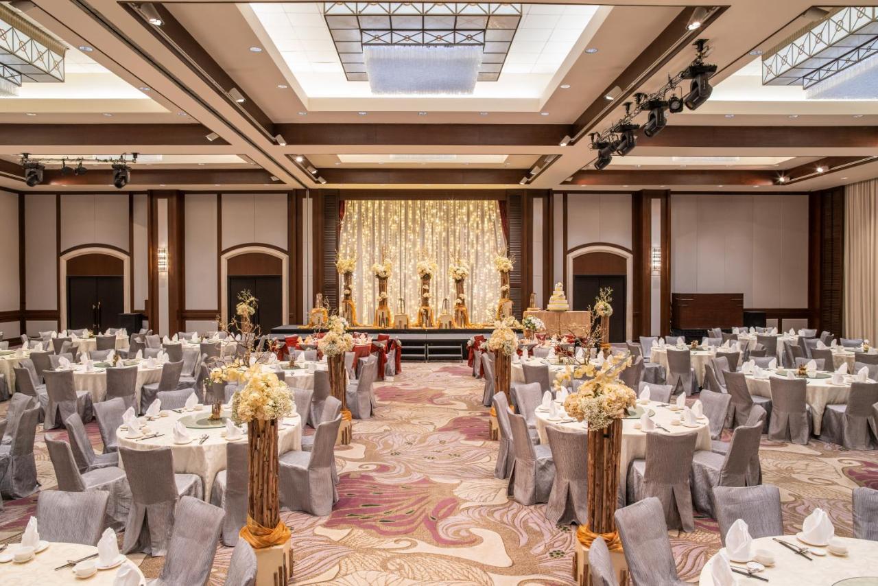 Paradox Singapore Merchant Court At Clarke Quay Екстериор снимка The photo shows an elegantly arranged banquet or event hall. There are several round tables covered with white tablecloths and decorated with floral centerpieces, creating a sophisticated atmosphere. The chairs are covered in grey fabric, complementi