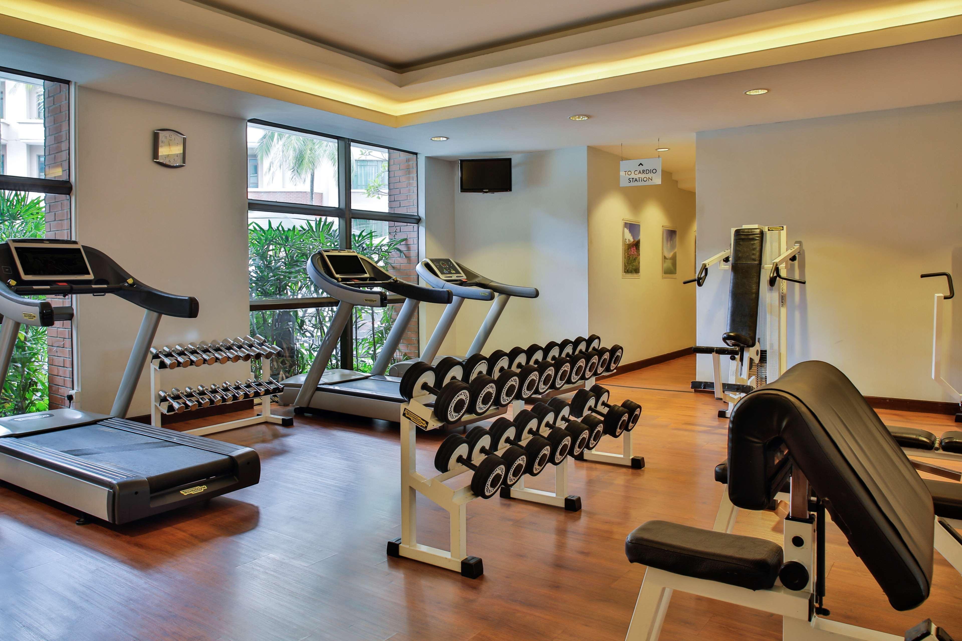 Paradox Singapore Merchant Court At Clarke Quay Екстериор снимка The photo shows a gym or fitness area featuring various exercise equipment. There are two treadmills positioned near a window, allowing natural light to brighten the space. A set of dumbbells is neatly organized on a rack, prominently displayed. Addi
