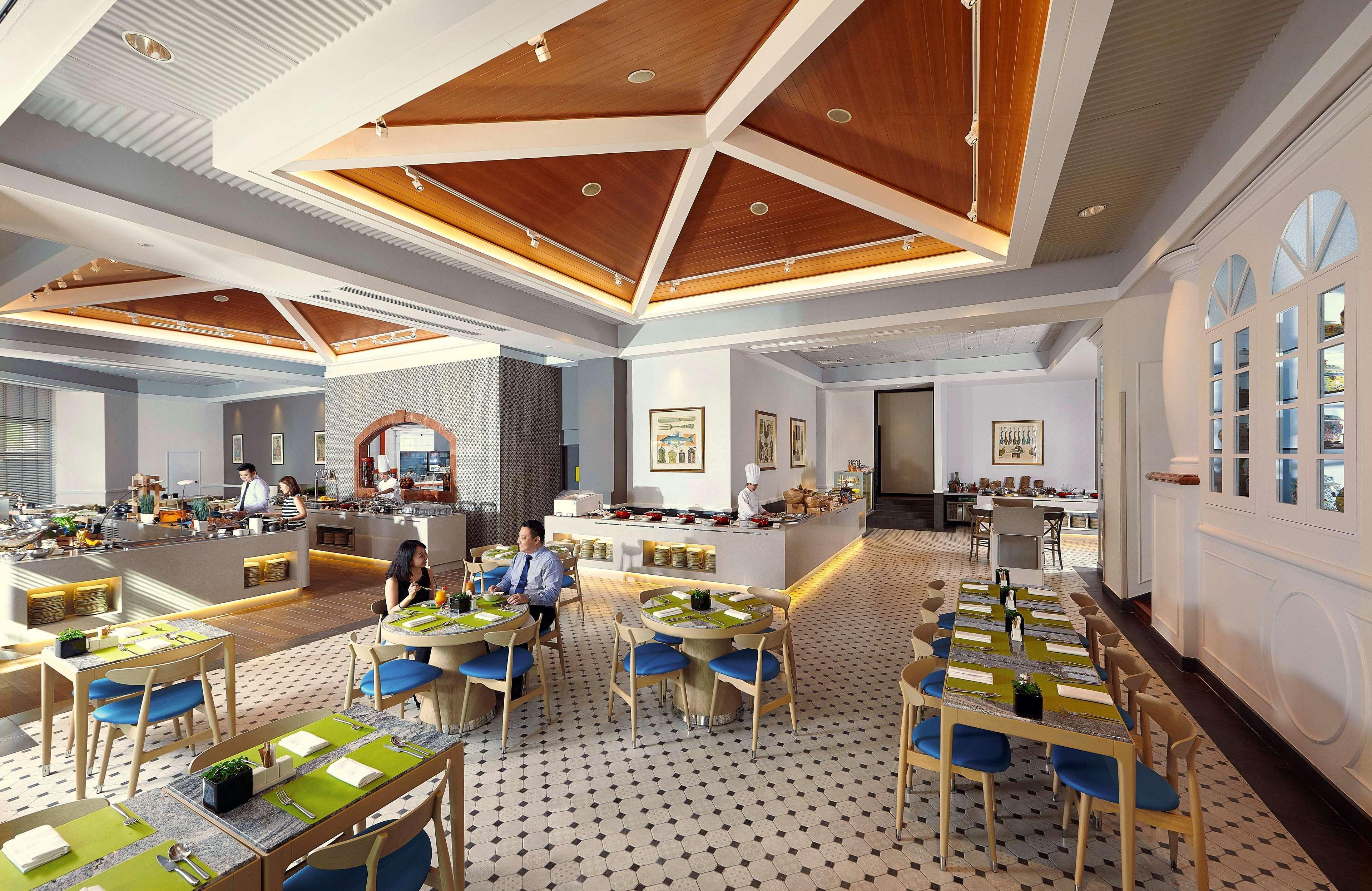 Paradox Singapore Merchant Court At Clarke Quay Екстериор снимка The photo shows a modern restaurant interior with a spacious layout. The ceiling features a geometric wooden design, adding a touch of elegance. The floor has a checkered pattern, contributing to the decor's stylish feel. 

There are several tables a