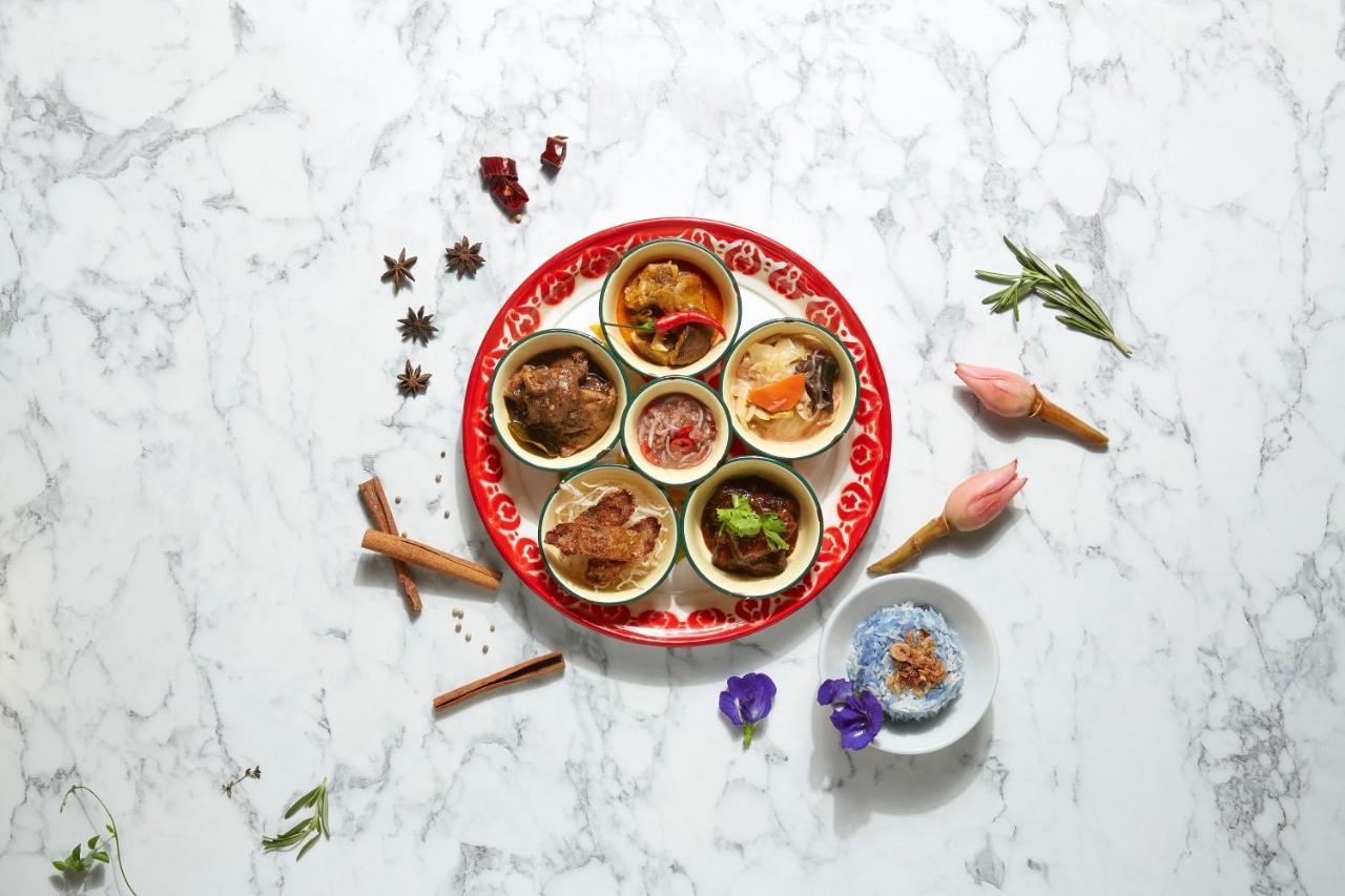Paradox Singapore Merchant Court At Clarke Quay Екстериор снимка The photo features a beautifully arranged plate with several small bowls containing different dishes. The plate itself has a vibrant red design, and the bowls are filled with a variety of colorful and textured foods. Surrounding the plate are some de